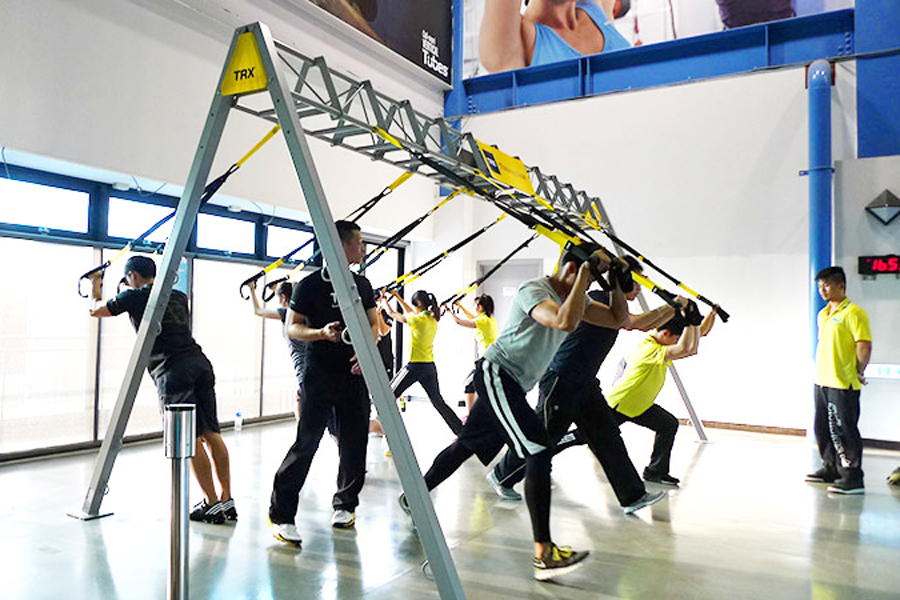 TRX懸掛式訓練,此組圖有二張照片,照片內容為一群學員在訓練的狀況,以及幾個教練在旁觀察學員動作